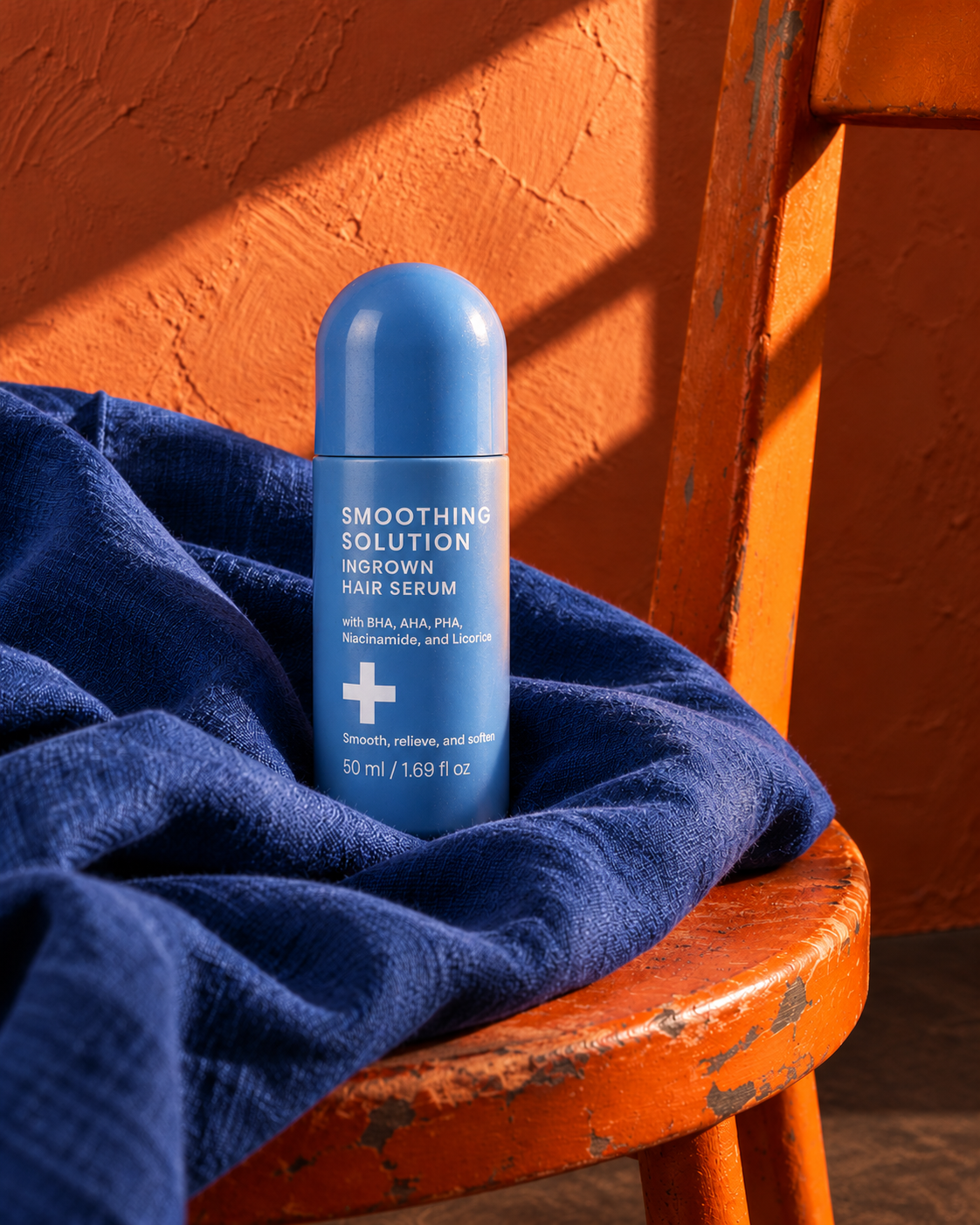 Styled image: the sky-blue 50 mL roll-on on blue fabric on an orange wooden chair